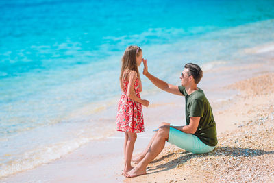 Full length of father and daughter on beach