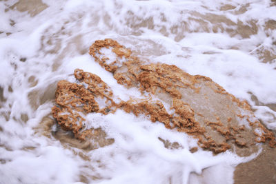 High angle view of rocks in sea during winter