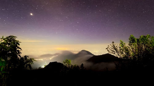 Scenic view of silhouette mountains against sky at night