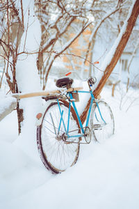 Old antique bike covered with snow in winter time