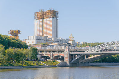 Arch bridge over river against buildings in city