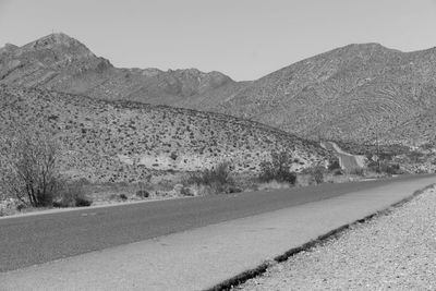 Road by mountains against clear sky