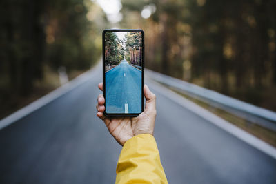 Midsection of person holding mobile phone