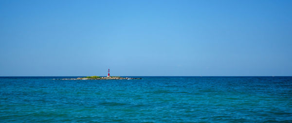 Scenic view of sea against clear blue sky