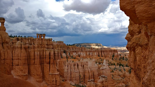 Panoramic view of rock formations against cloudy sky