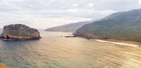 Scenic view of sea and mountains against sky