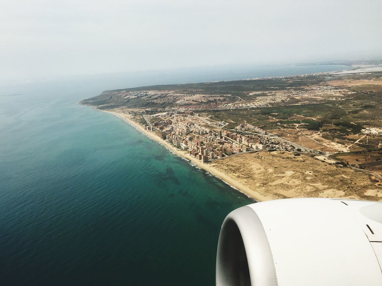 sea, water, horizon over water, mode of transport, aerial view, transportation, scenics, airplane, part of, beauty in nature, tranquil scene, nature, air vehicle, cropped, tranquility, sky, flying, nautical vessel, travel, clear sky