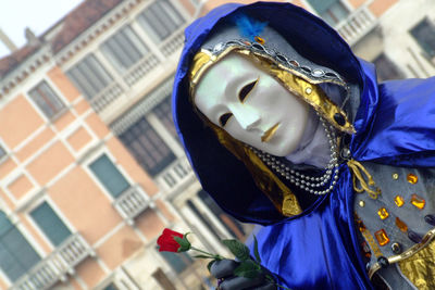 Close-up of person dressed up for carnival against building