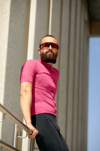 Portrait of young man wearing sunglasses while standing in gym