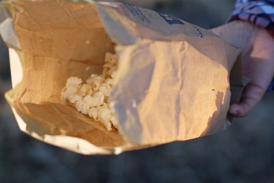 Cropped hand holding paper with popcorn