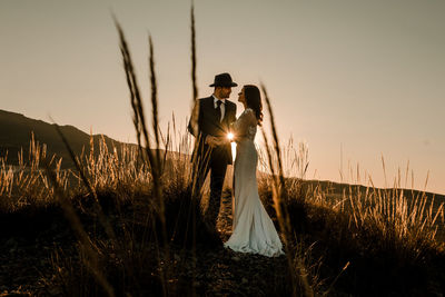 Couple in a field at sunset among dry plants. wedding concept