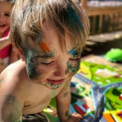 Close-up of shirtless boy with paint on face