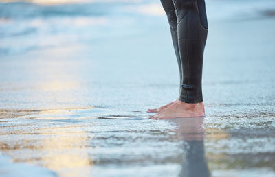 Low section of person standing on beach