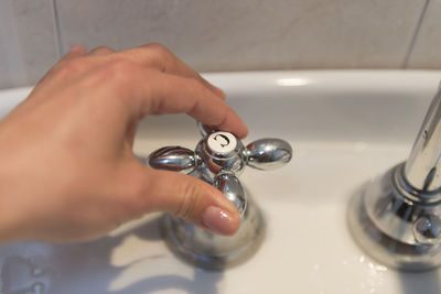 Close-up of hand holding tap
