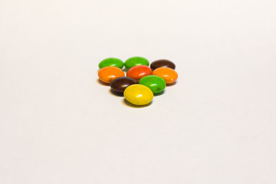 High angle view of multi colored candies on white background