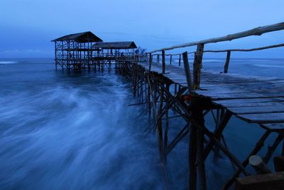 Pier on sea against sky at dusk