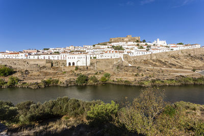 Buildings in city against blue sky