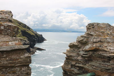 Rocks on sea shore against sky