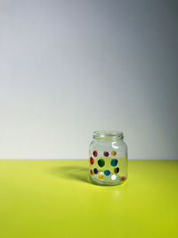 Multi colored jar on table against wall