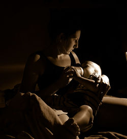 Young woman sitting on bed at home