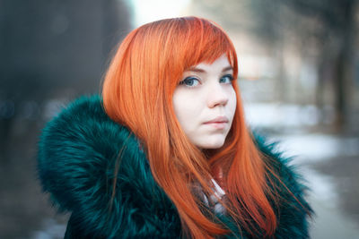 Close-up portrait of young woman wearing fur coat during winter