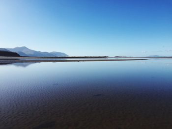 Scenic view of calm lake against blue sky