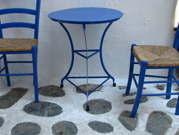 Empty chairs and table against blue wall