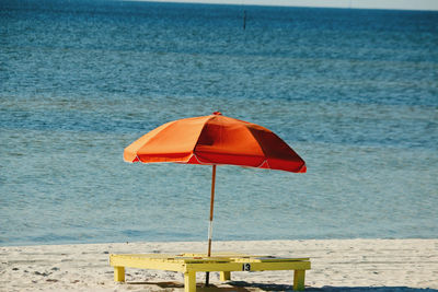 Beach umbrella on shore against sea