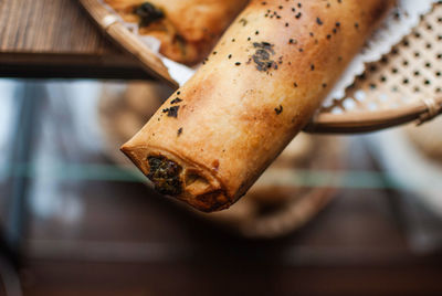 Close-up of breads in wicker plate on wooden table at bakery