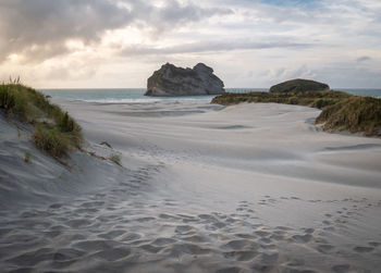 Beach with white sand, shot during sunset on wharariki beach, new zealand