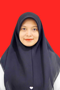 Portrait of young woman wearing hijab against yellow background