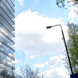 Low angle view of modern building against cloudy sky