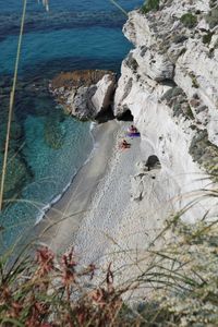 High angle view of people on rocks at beach