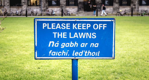 Close-up of warning sign on grass