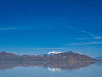 Scenic view of lake and mountains against blue sky