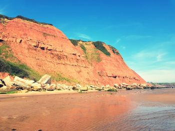 Scenic view of mountain by sea against sky