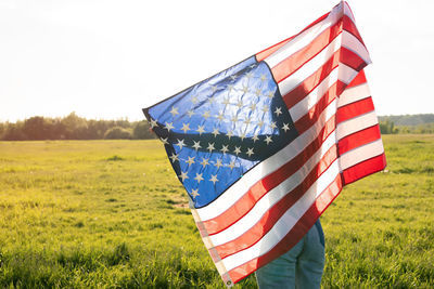 Low section of flag on field against clear sky