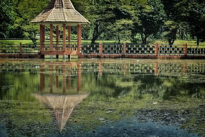 Built structure by lake against trees