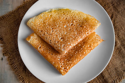 Pancakes on a white plate on a linen background. russian traditional food crepes for the holiday