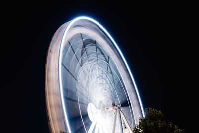 Low angle view of illuminated ferris wheel against sky at night