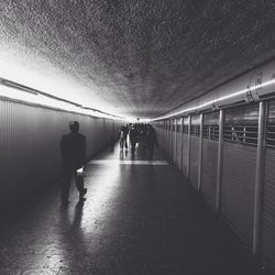 Rear view of men walking in corridor