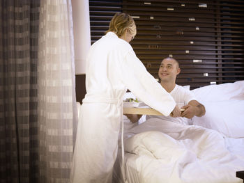 Woman sitting on bed in bedroom