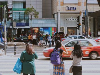 Rear view of women walking on street in city