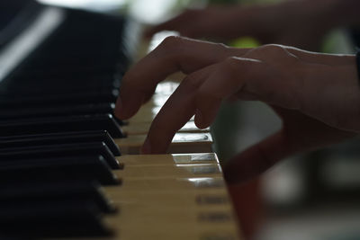 Close-up of hands playing piano