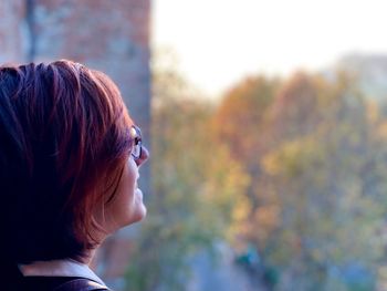 Redhead woman against trees in city