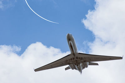 Low angle view of airplane flying against sky