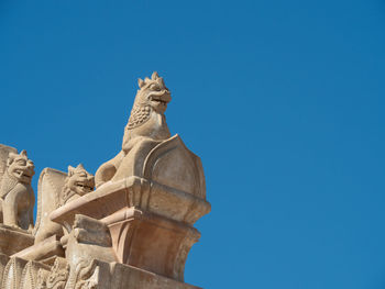 Low angle view of statue against blue sky