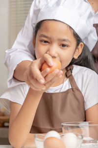 Portrait of a boy holding ice cream on table