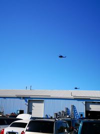 Low angle view of airplane flying against clear blue sky