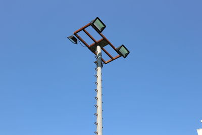 Low angle view of floodlight against blue sky